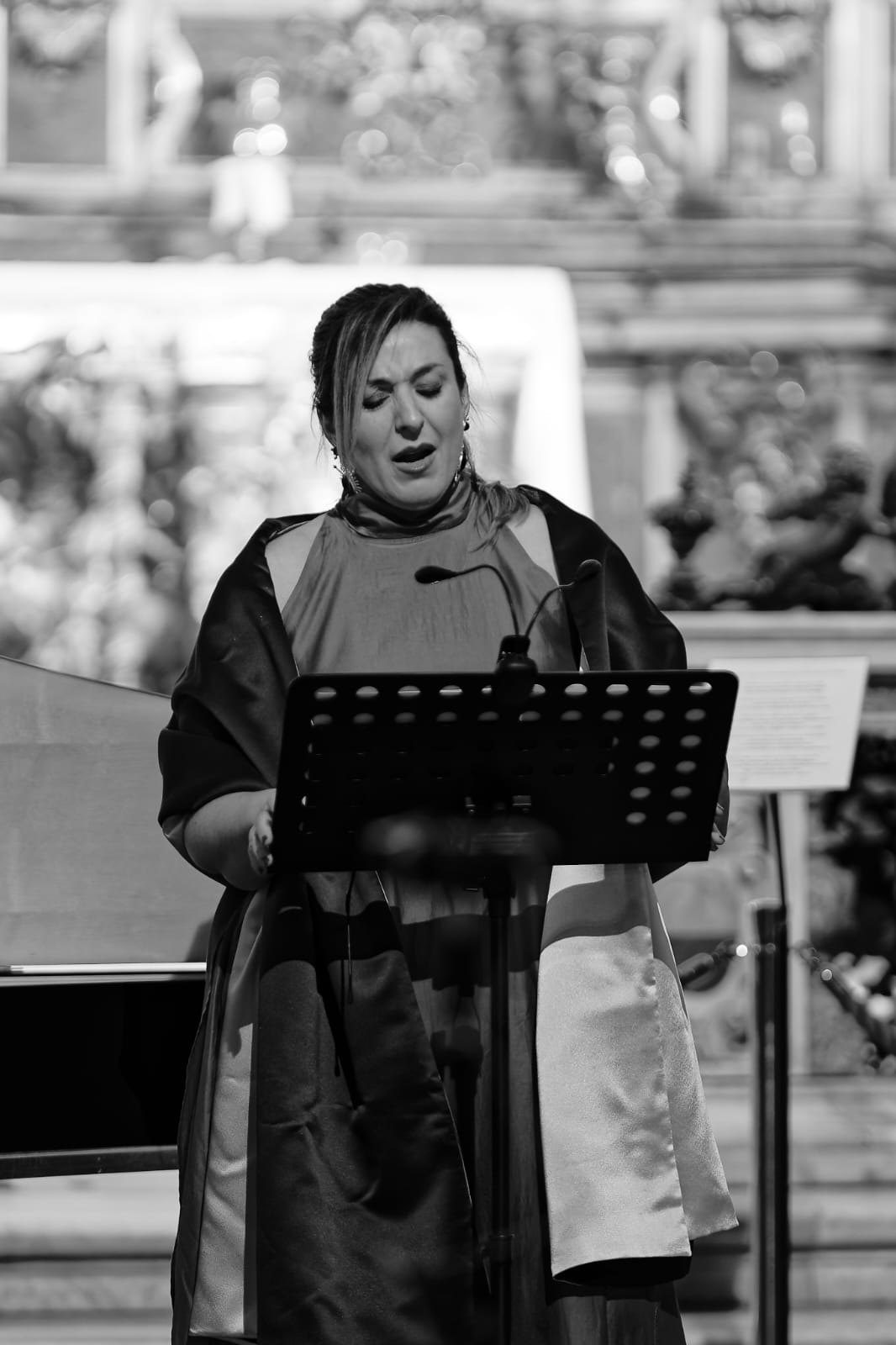 Paloma Chiner cantando ante el atril, con el clave detrás